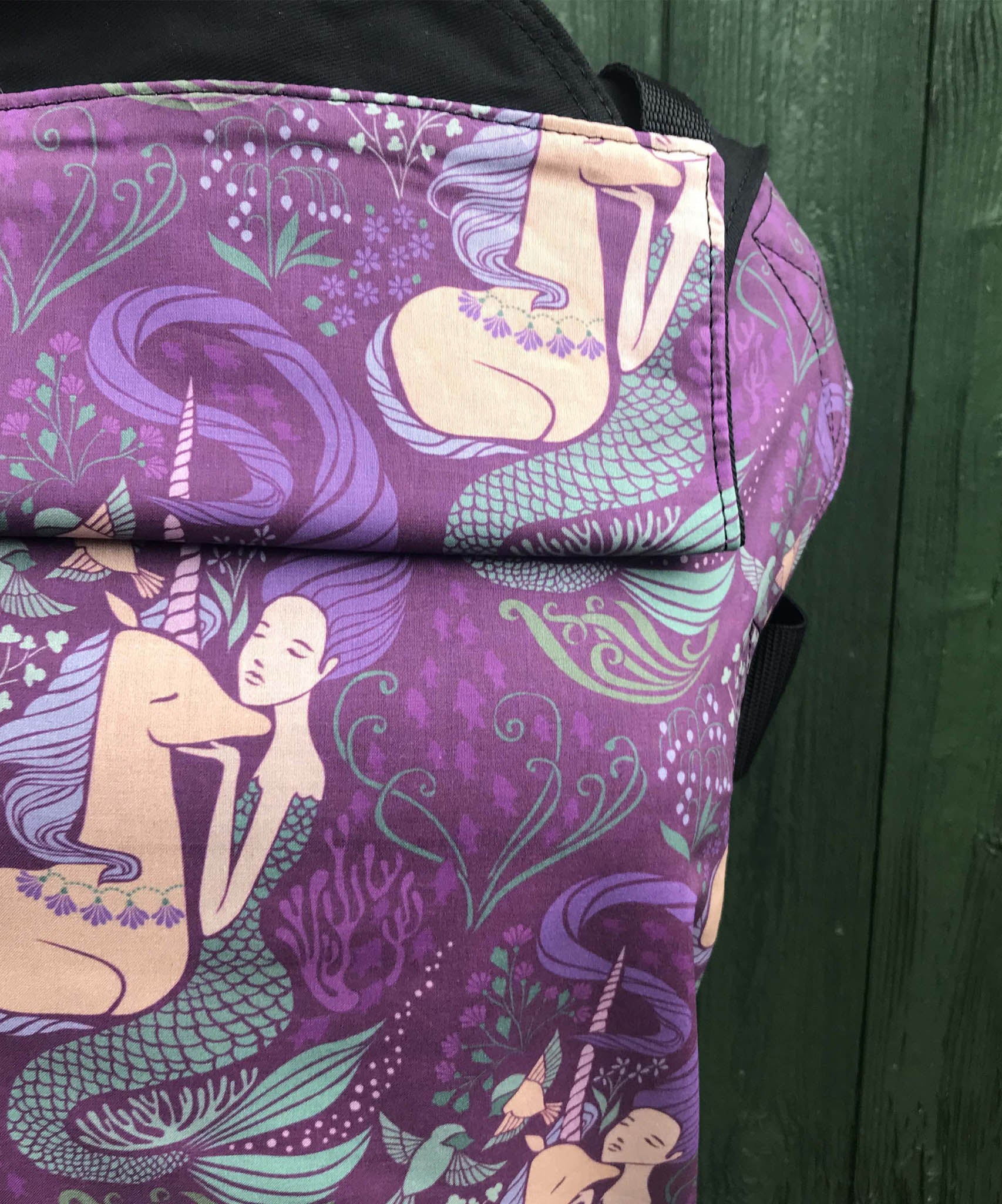 A close up of the beautiful mermaid and unicorn design on the Integra memraid and unicorn baby carrier available at Babipur.