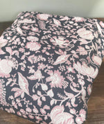 Integra Peta baby carrier available at a Babipur a dark coloured carrier with a pink floral design. Features a small hood for head protection.