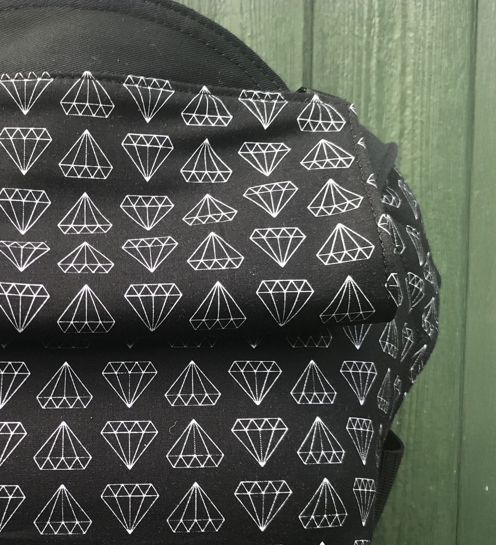A close up of the white geometric diamond print and hood detail on the Integra shine bright baby carrier available at Babipur.