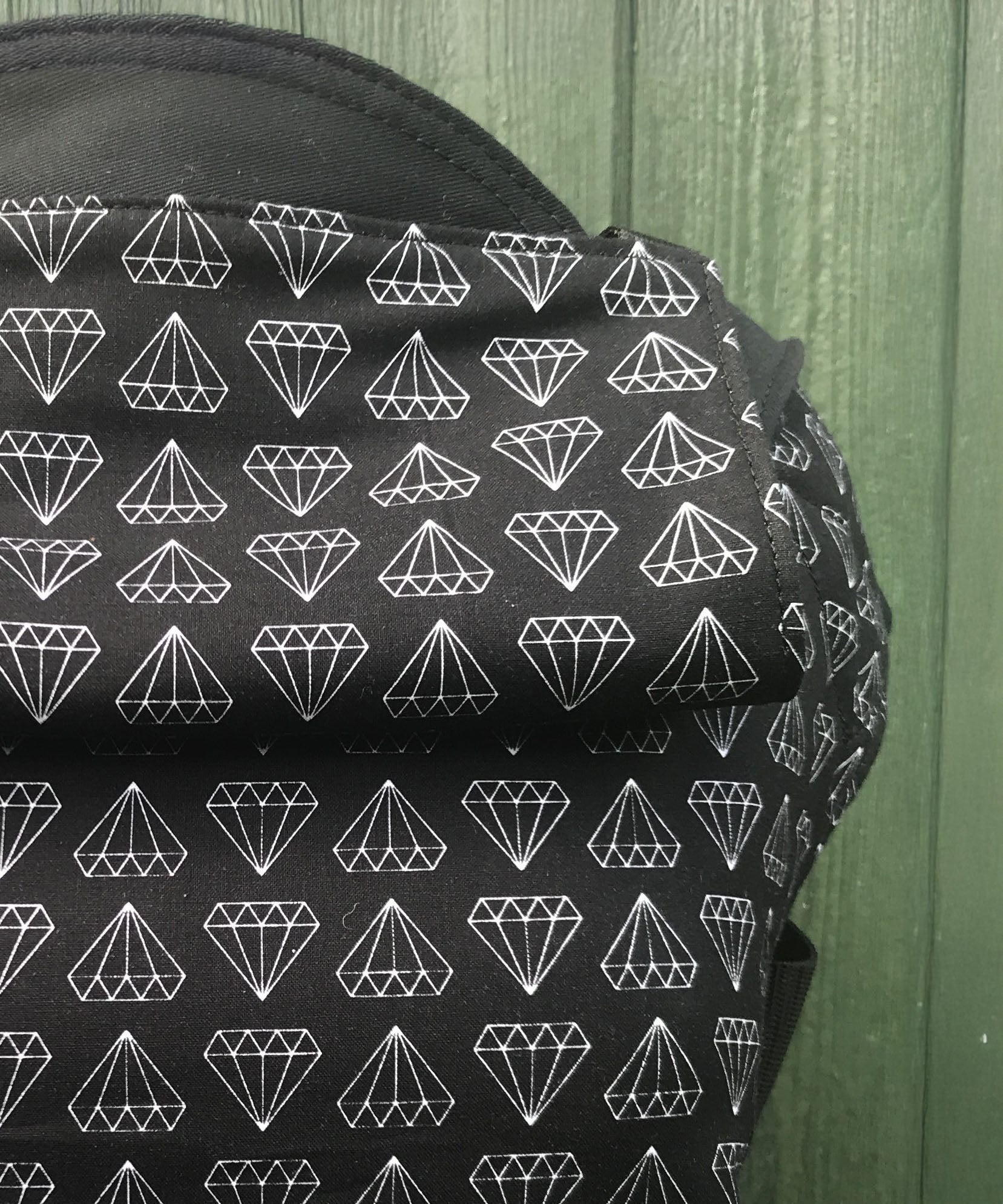 A close up of the white geometric diamond print and hood detail on the Integra shine bright baby carrier available at Babipur.