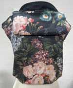 Integra vintage summer baby carrier available at a Babipur a dark coloured carrier with a vintage flower design. Features a small hood for head protection.