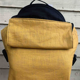 Integra ochre yellow texture linen baby carrier available at a Babipur. Features a small hood for head protection.