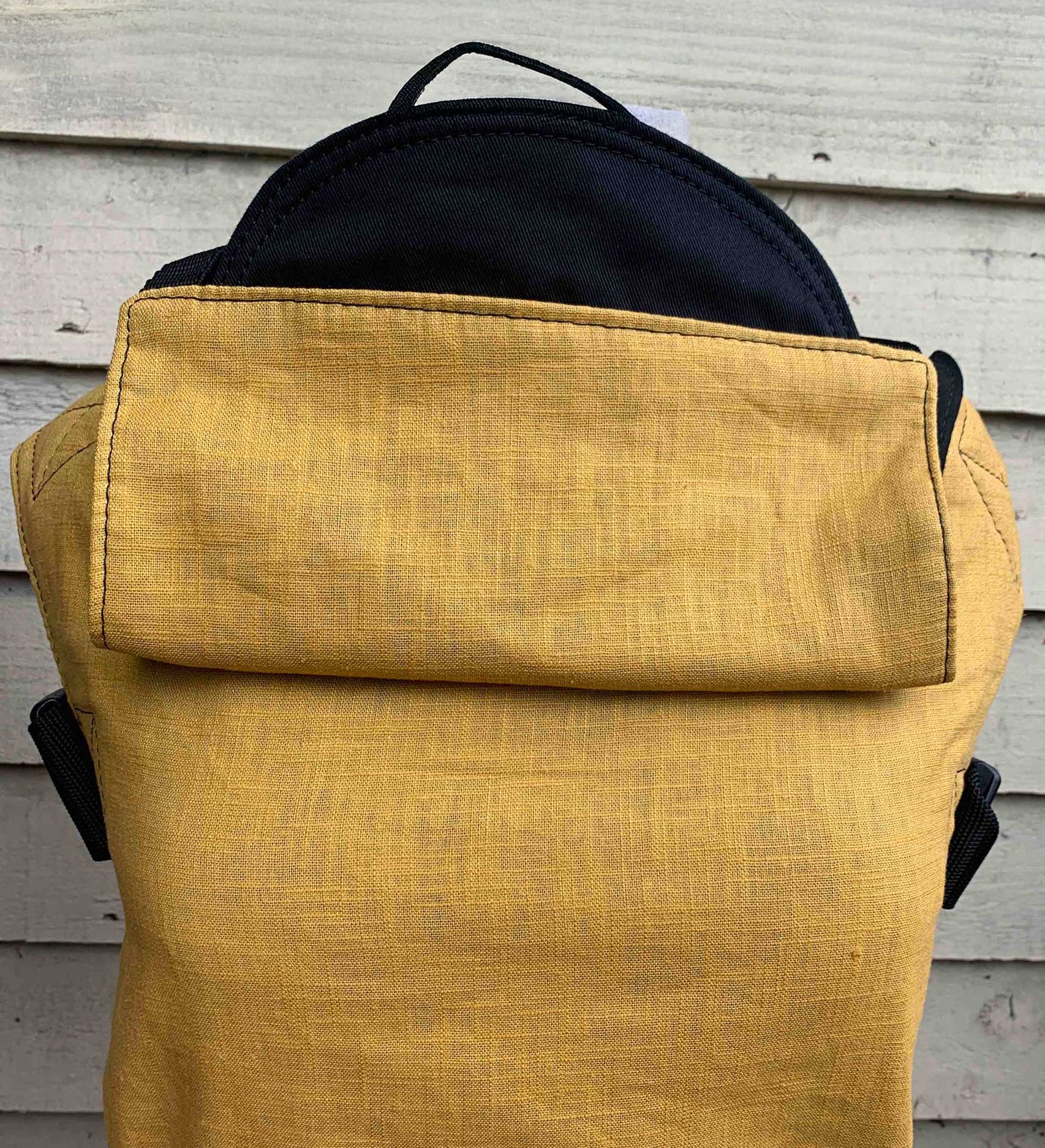 Integra ochre yellow texture linen baby carrier available at a Babipur. Features a small hood for head protection.