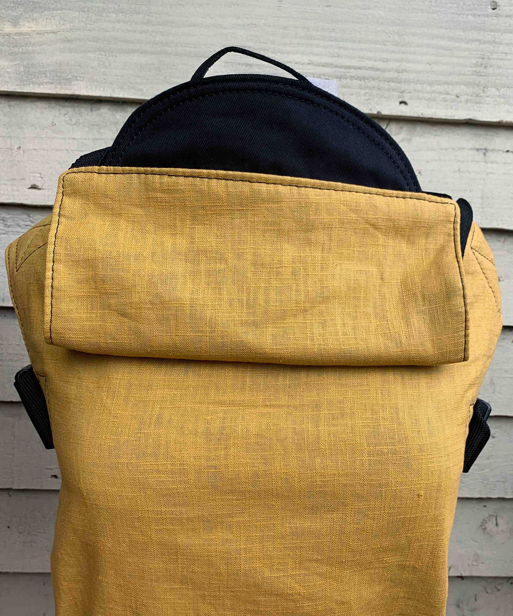 Integra ochre yellow texture linen baby carrier available at a Babipur. Features a small hood for head protection.
