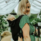 A mother carrying a baby in a Integra essential black carrier available at Babipur.
