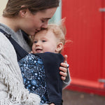 person babywearing using an Integra baby carrier with Copenhagen flowers print