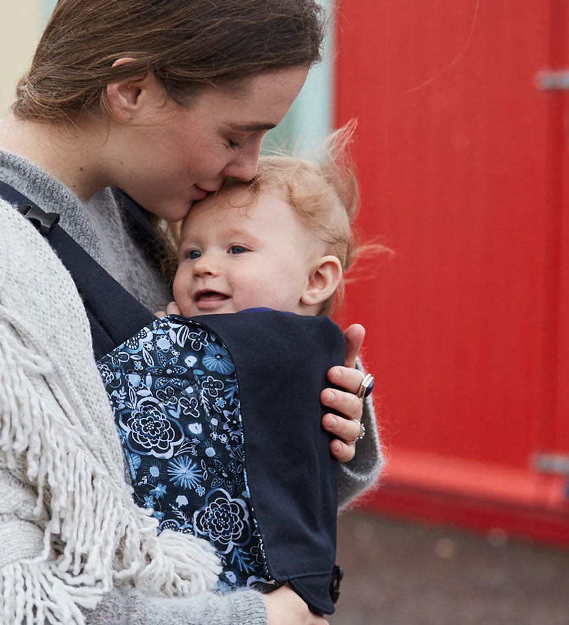 person babywearing on their front using an Integra baby carrier with Copenhagen flowers print
