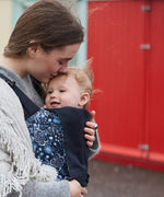 A mother carrying a baby in a Integra Copenhagen flower carrier available at Babipur.