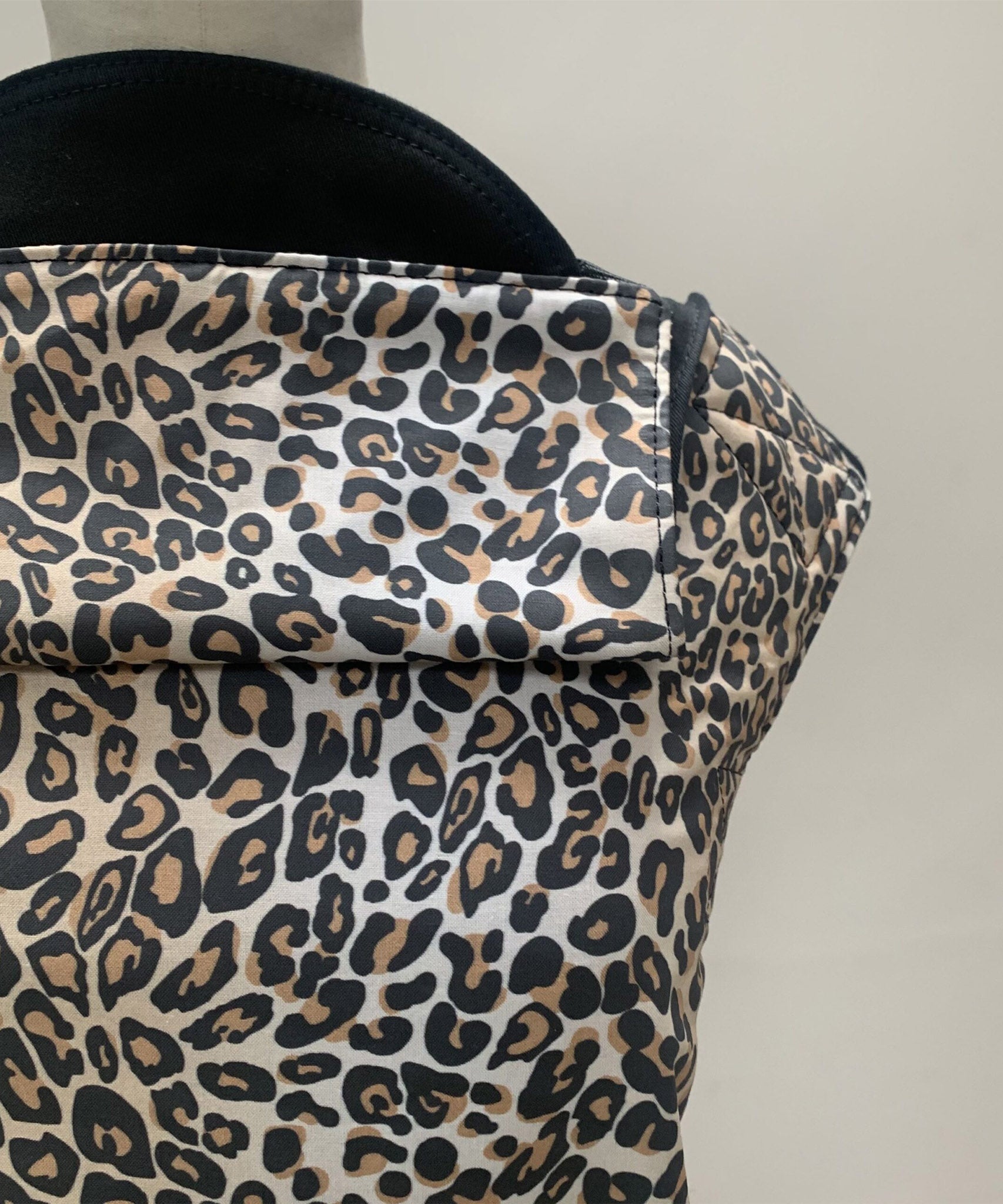 A close up of the leopard print and hood detail on the Integra baby carrier available at Babipur.