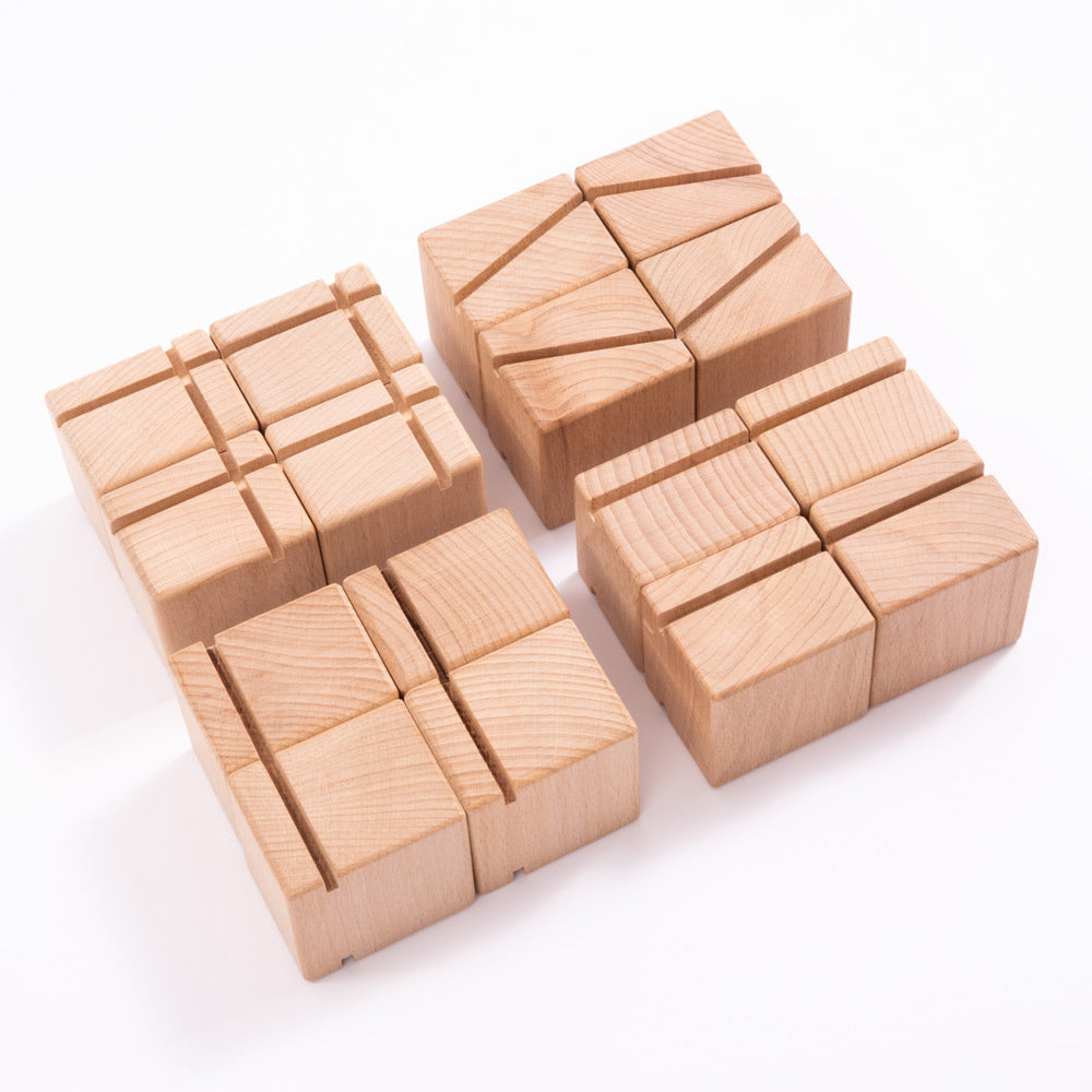 Close up of the Just Blocks smart lines eco-friendly wooden slotting shape toys laid out on a white background