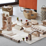 Just Blocks plastic-free wooden blocks stacked in a town scene on a grey carpet