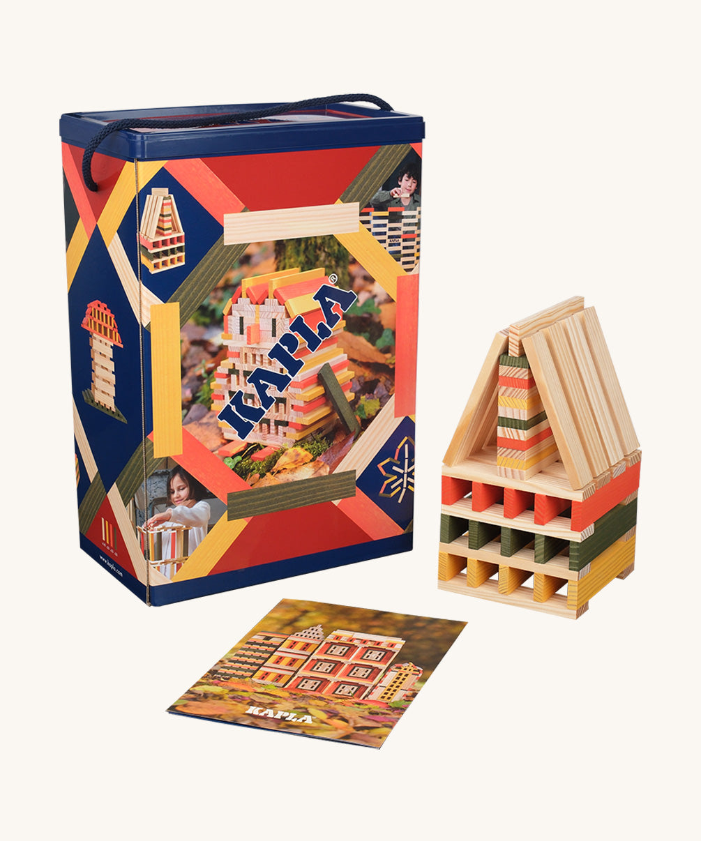 The Kapla 200 Autumn coloured building planks box, next to a small sculpture and an inspiration leaflet.
