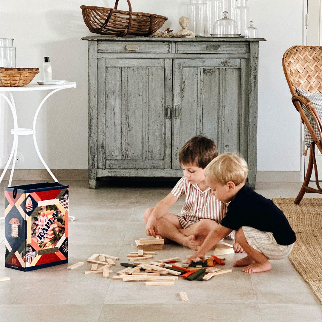Children playing with the Kapla 200 Autumn coloured wooden plank building block toys.