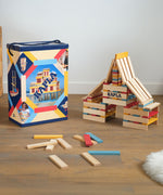 KAPLA Wooden Building Blocks 200 Box in Summer colours. A build can be seen by the side of the box with a few blocks on the floor. 