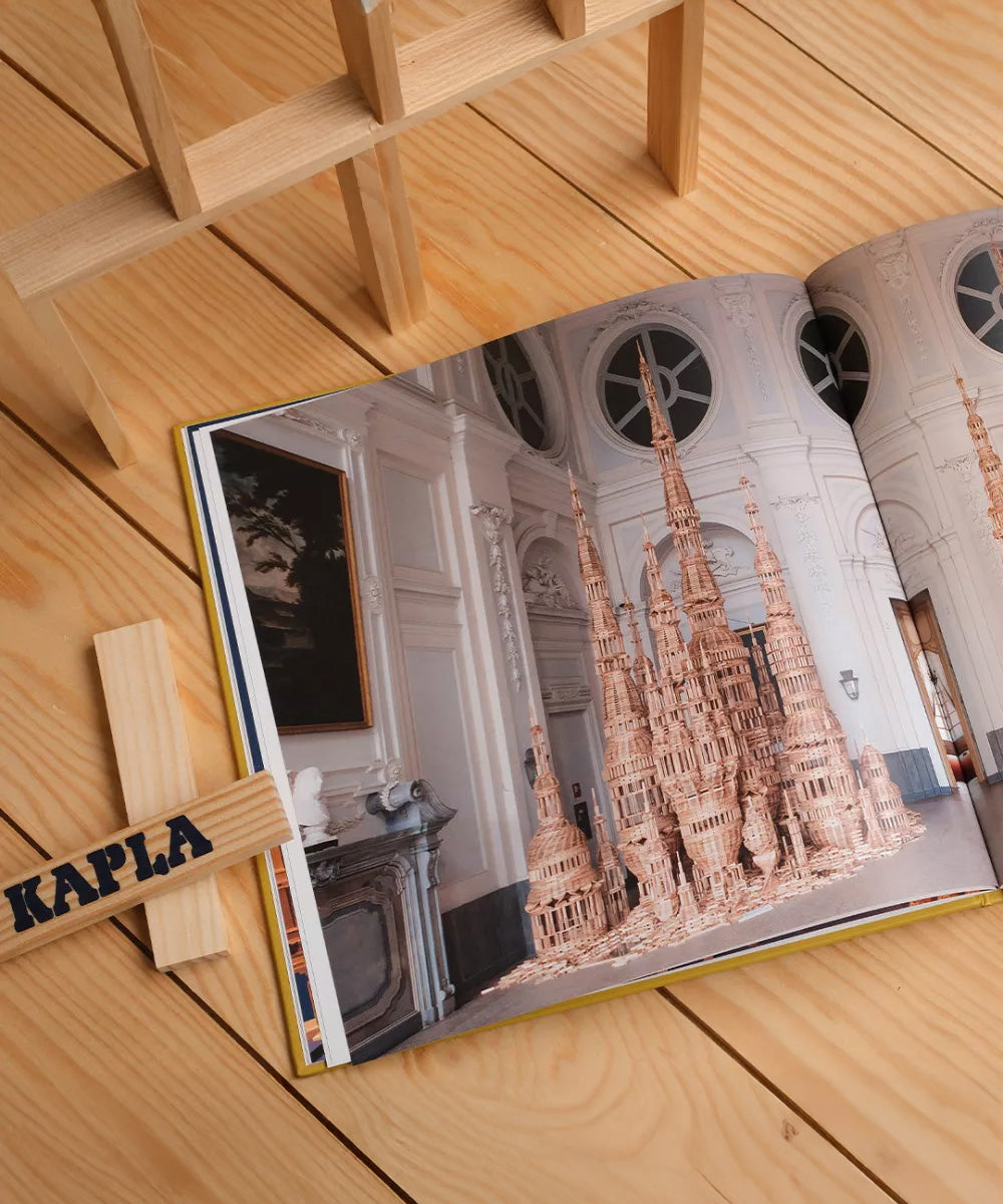 The Kapla Best Of artist collector's book, opened to show a page with a picture of a wooden Kapla sculpture.