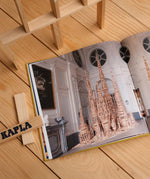The Kapla Best Of artist collector's book, opened to show a page with a picture of a wooden Kapla sculpture.