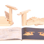Wooden swan models next to the Kapla easy animals art book on a white background