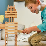 Child building a robot made from the natural Kapla wooden construction planks 