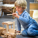 Child building a train made from the natural Kapla wooden construction planks 