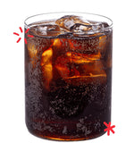 Glass of Karma Cola served over ice, showing the deep colour and natural fizz of this organic Fairtrade cola made with real kola nuts.