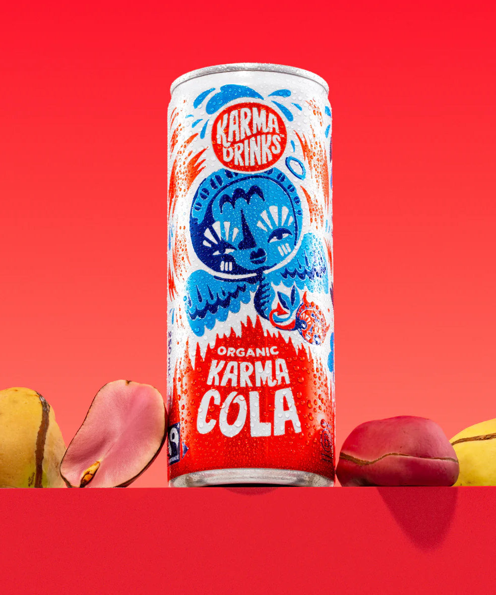 Karma Drinks Organic Fairtrade Cola can displayed with real kola nuts, highlighting its natural ingredients and ethical sourcing.