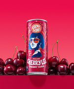 Can of Karma Drinks Cherry Lee organic cherry soda displayed with fresh cherries, showcasing its natural cherry flavour and Fairtrade certification.