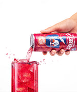 Karma Drinks Cherry Lee organic cherry soda being poured from the can into a glass of ice, highlighting the vibrant red colour and Fairtrade branding.