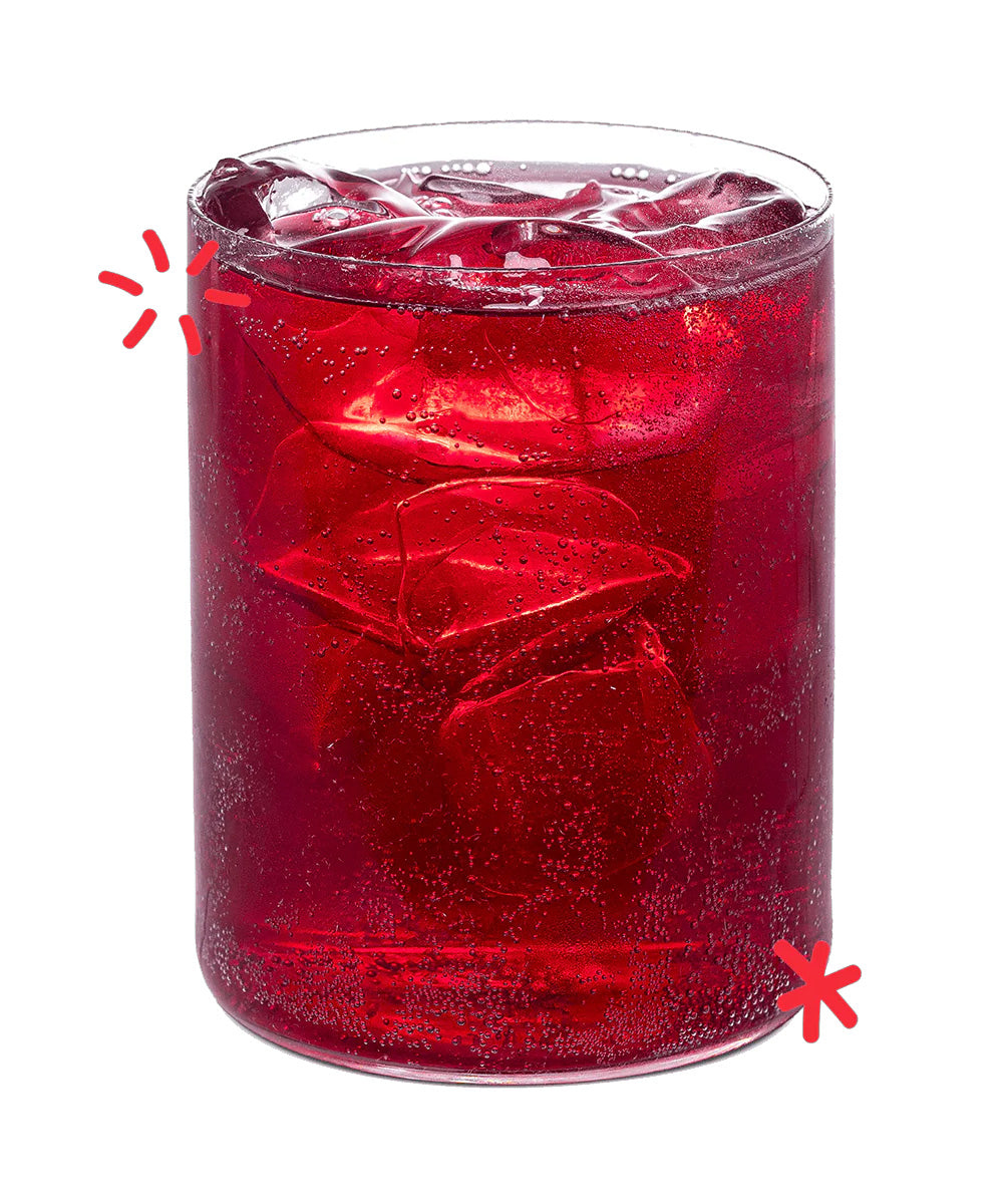 Bright red organic Cherry Lee cherry soda poured over ice, showing the colour and fizz of Karma Drinks’ Fairtrade cherryade.