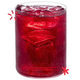 Bright red organic Cherry Lee cherry soda poured over ice, showing the colour and fizz of Karma Drinks’ Fairtrade cherryade.