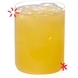 Organic orangeade served over ice, showing the bright citrus colour and refreshing fizz of Karma Drinks’ Fairtrade orange soda.