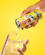 Karma Drinks Tropikool organic mango & passionfruit soda, poured into a glass with ice. 