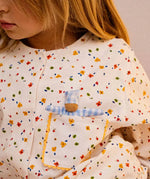 The doll from the Käthe Kruse soft toy baby with a blue check sleeping bag in a child's pocket. 
