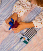 Käthe Kruse soft toy baby with a blue check sleeping bag. 
