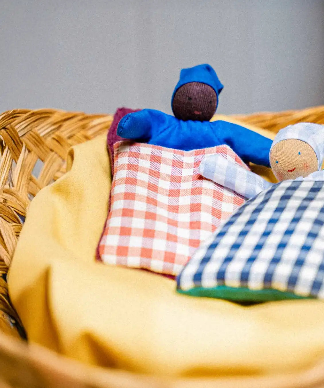 Käthe Kruse baby with red check sleeping bag.