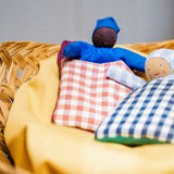Käthe Kruse baby with red check sleeping bag.
