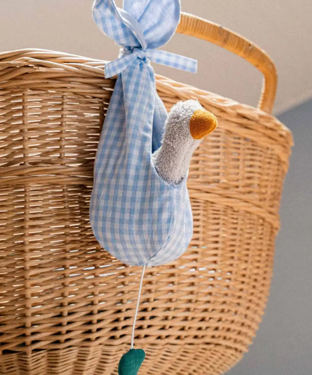 Käthe Kruse white duckling nest animal music box. Small white duckling soft toy in a blue and white check material nest.