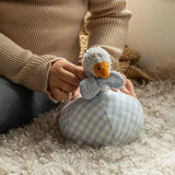Child playing with Käthe Kruse Ebba Duck Rattle & Ball Sensory Toy in cotton terry cloth and blue gingham, with soft duck rattle in baby grasping ball.