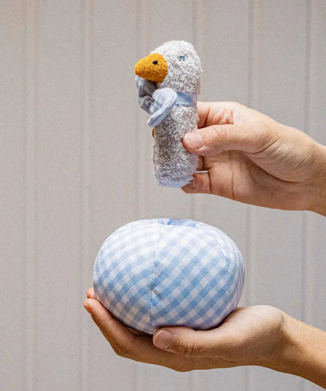 Käthe Kruse Ebba duck soft toy rattle and ball. Small duck wearing a blue and white check bowtie that can be placed inside a matching ball. 