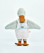 Käthe Kruse Eva duck standing soft toy wearing a white apron with red dots  showing a blue waldorf doll in apron pocket