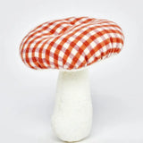 A standing Kathe Kruse mushroom soft grabber toy. Showing a red gingham top and white stem