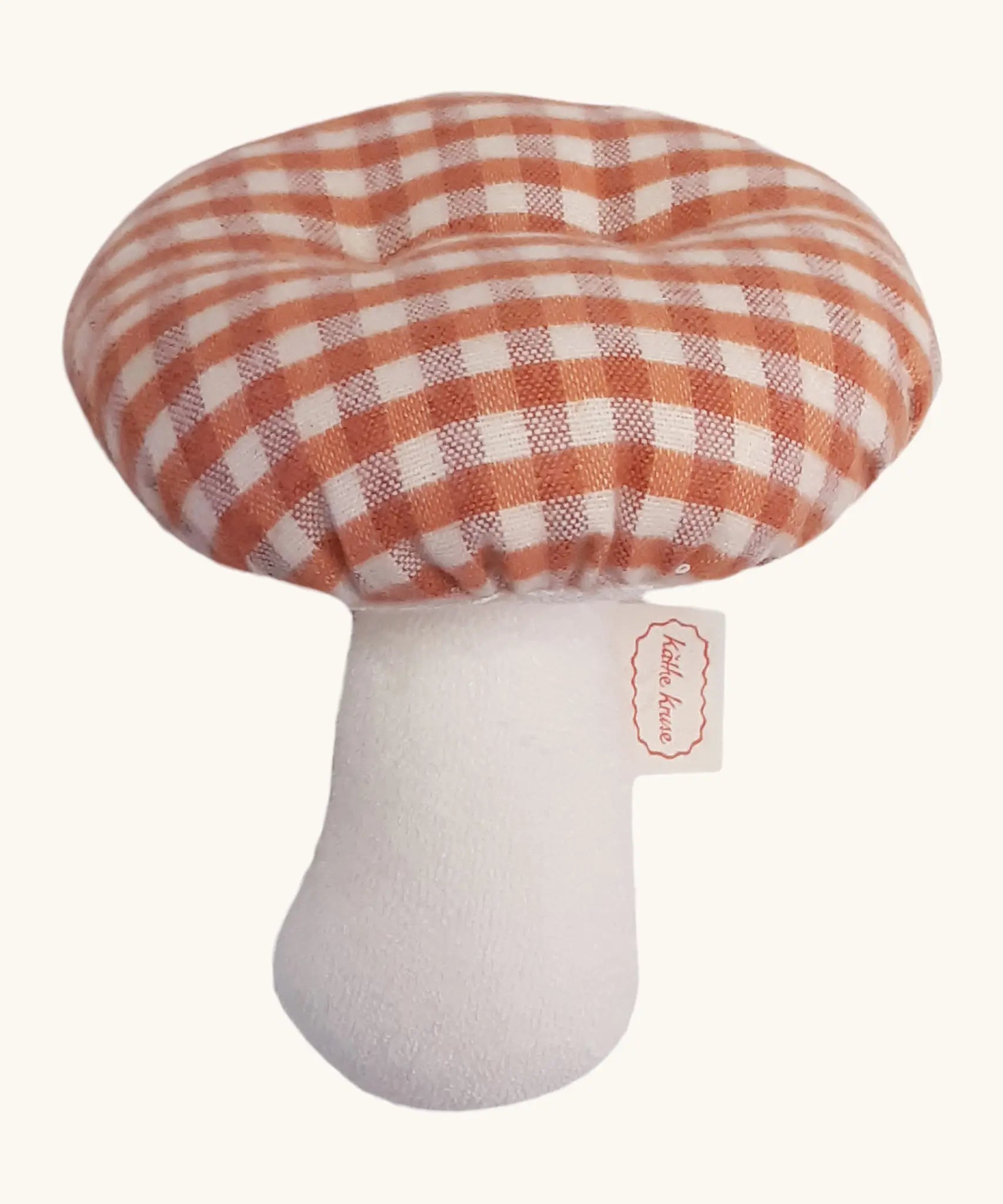 A Kathe Kruse mushroom soft grabber toy. Showing a red gingham cap and white stem