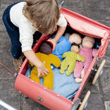 Child playing with Kathe Kruse nana Saffron waldorf doll with other waldorf dolls in a pram