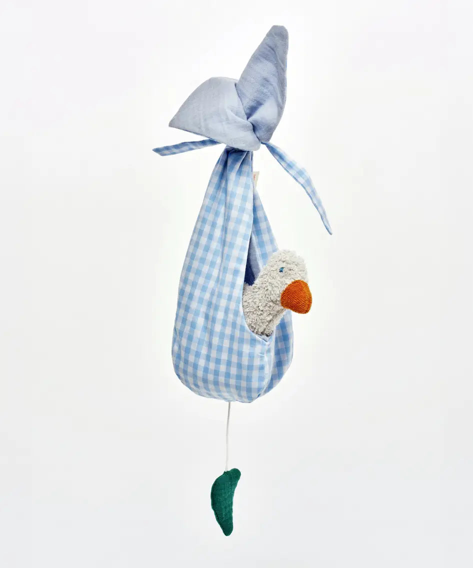 Small white duckling toy sitting inside blue ginham fabric nest from the Kathe Kruse animal music box set