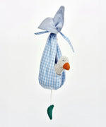 Small white duckling toy sitting inside blue ginham fabric nest from the Kathe Kruse animal music box set