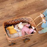 Käthe Kruse Waldorf Doll Nini Sunshine. and large Waldorf doll placed in a wicker dolls pram pushed by a child.