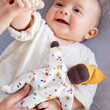 Käthe Kruse Waldorf Doll Nini Sunshine placed in the crook of a baby's arm.