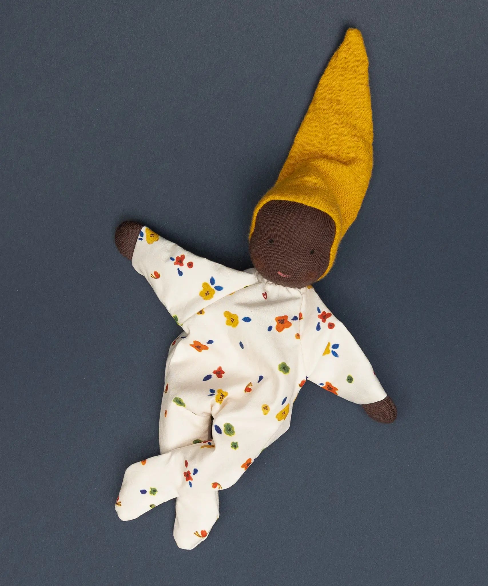 Käthe Kruse handmade Waldorf Doll Nini Sunshine with the legs crossed.