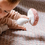 Käthe Kruse baby pilz grabbing toy, a red and white gingham topped toadstool shaped soft toy. 