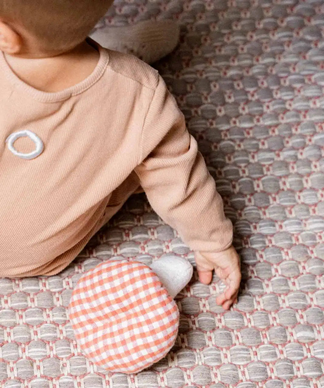  Käthe Kruse baby pilz grabbing toy, a red and white gingham topped toadstool shaped soft toy. View of top of mushroom.