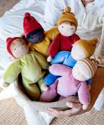 Adult carrying a basket full of Kathe Kruse nana waldorf dolls.
